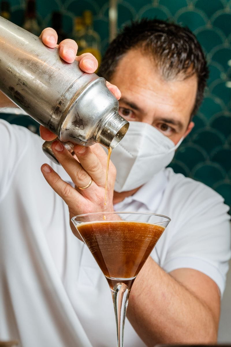 Mixologue servant une boisson dans un verre à Martini à Tenerife.