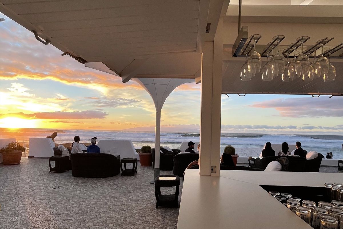 Terrasse à Tenerife avec des gens regardant le coucher de soleil au-dessus de la mer.