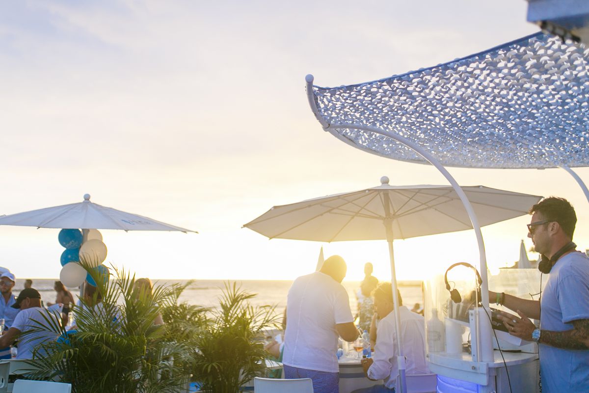 Des gens s’amusent sur une terrasse au bord de la mer à Tenerife au coucher du soleil.