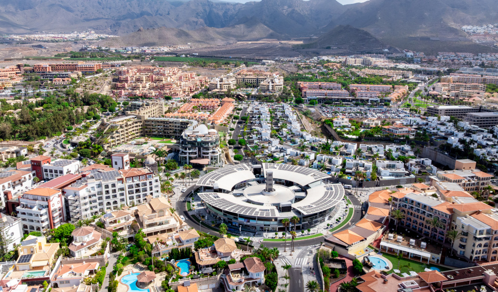 Vue aérienne de Costa Adeje à Tenerife avec des bâtiments et des montagnes en arrière-plan.