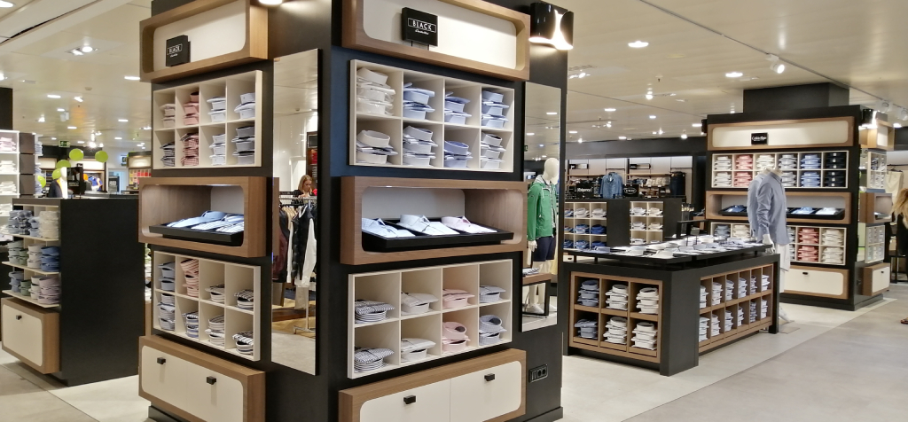 Des chemises exposées sur des étagères à l’intérieur d’un magasin de vêtements à Tenerife.