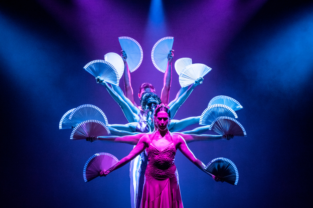 Des danseurs sur scène avec des fans illuminés lors d’un spectacle à Tenerife.