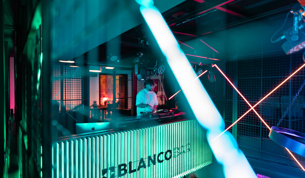 DJ jouant de la musique au Blanco Bar, à Tenerife, illuminé par des néons.