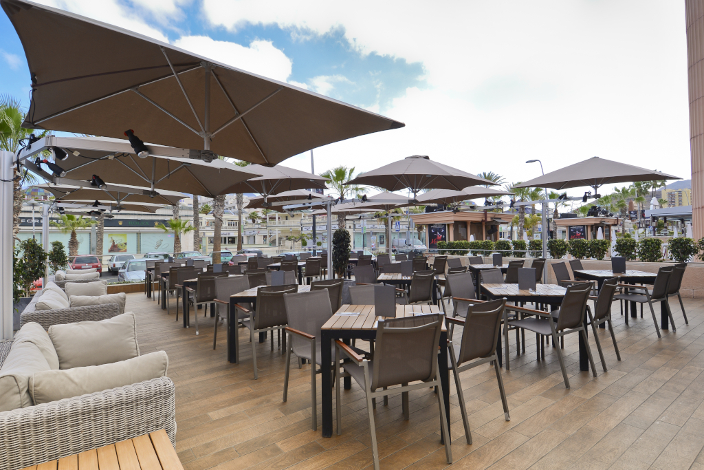 Terrasse avec tables et chaises sous parapluies dans le centre commercial de Tenerife.