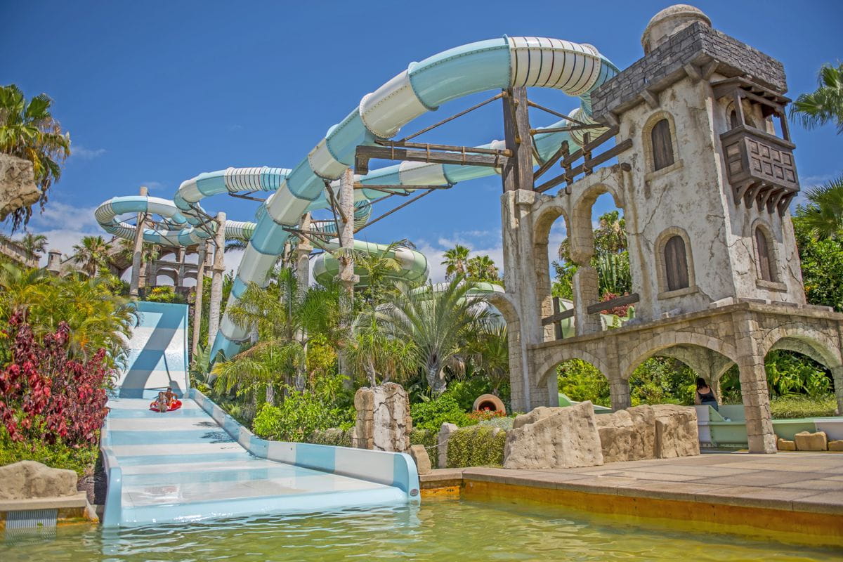 Toboggan aquatique dans le parc à thème de Tenerife avec végétation tropicale.