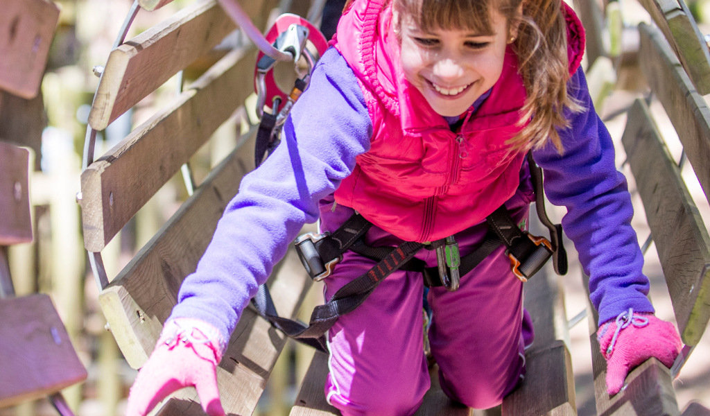 Petite fille qui grimpe dans un parc d’aventure à Tenerife.