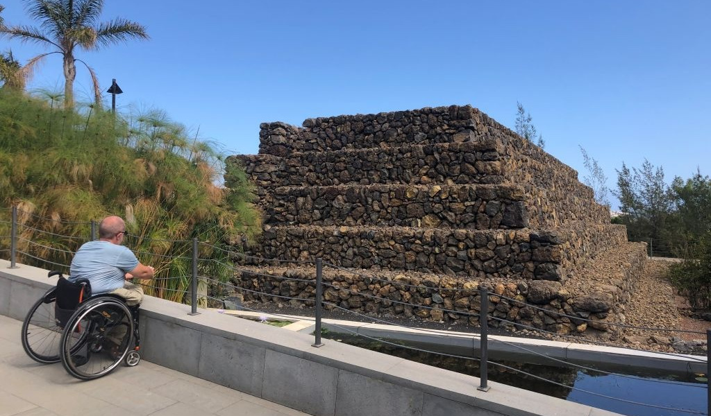 Personne en fauteuil roulant regardant une pyramide à Güímar, Tenerife.