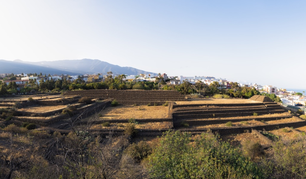 Pyramides de Güímar à Tenerife, avec des montagnes et une ville en arrière-plan.