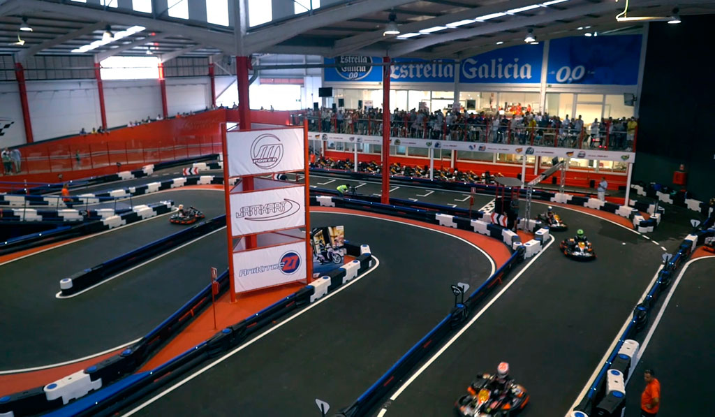 Circuit de karting en salle à Tenerife avec le public regardant la course.