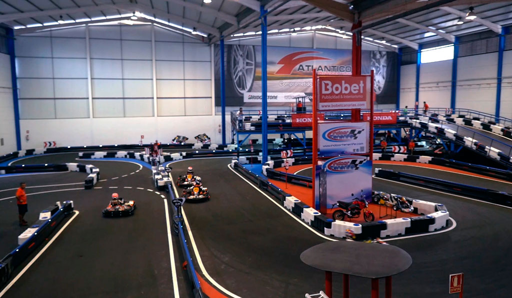 Piste de karting couverte à Tenerife avec des karts dans la course et un panneau Bobet.