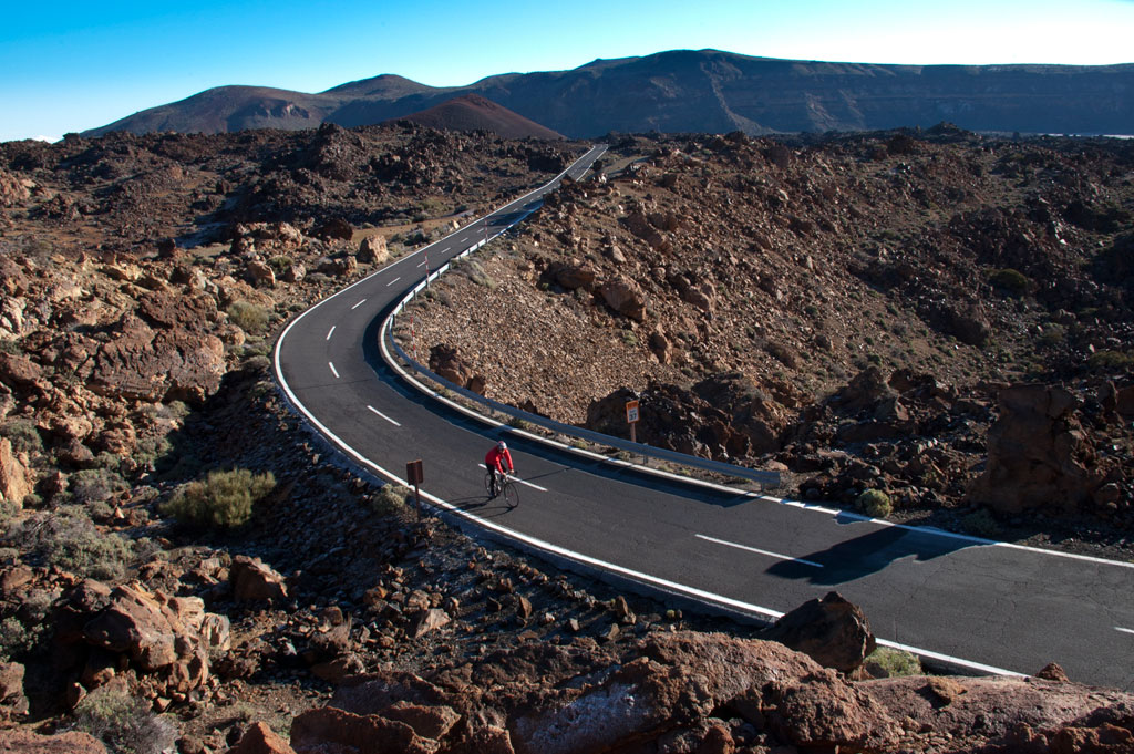 Cycliste sur la route entre les rochers du parc national de la Teide à Tenerife.