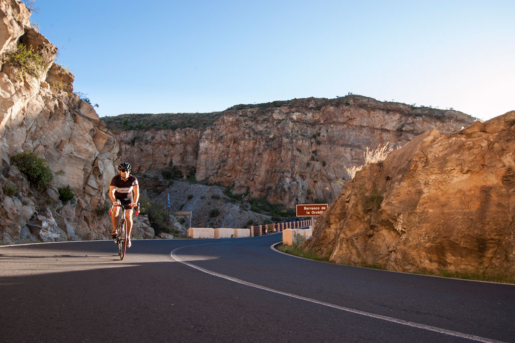 Cycliste sur la route du Barranco de la Orchilla, à Tenerife, près d’une falaise.
