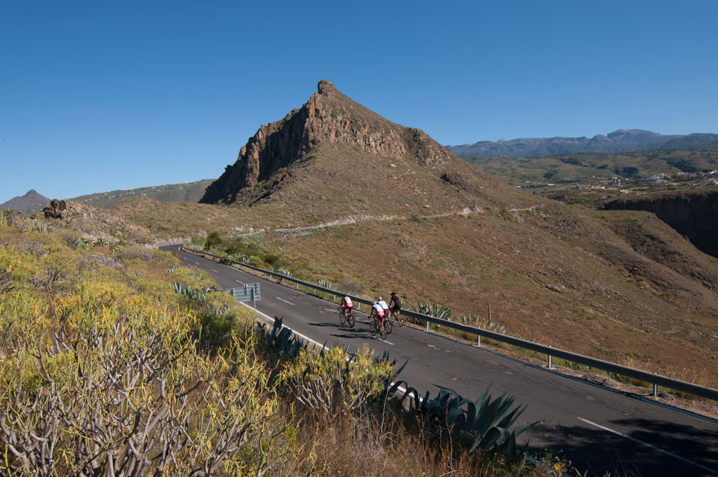 Cyclistes sur une route montagneuse à Tenerife, entourés de paysages arides.