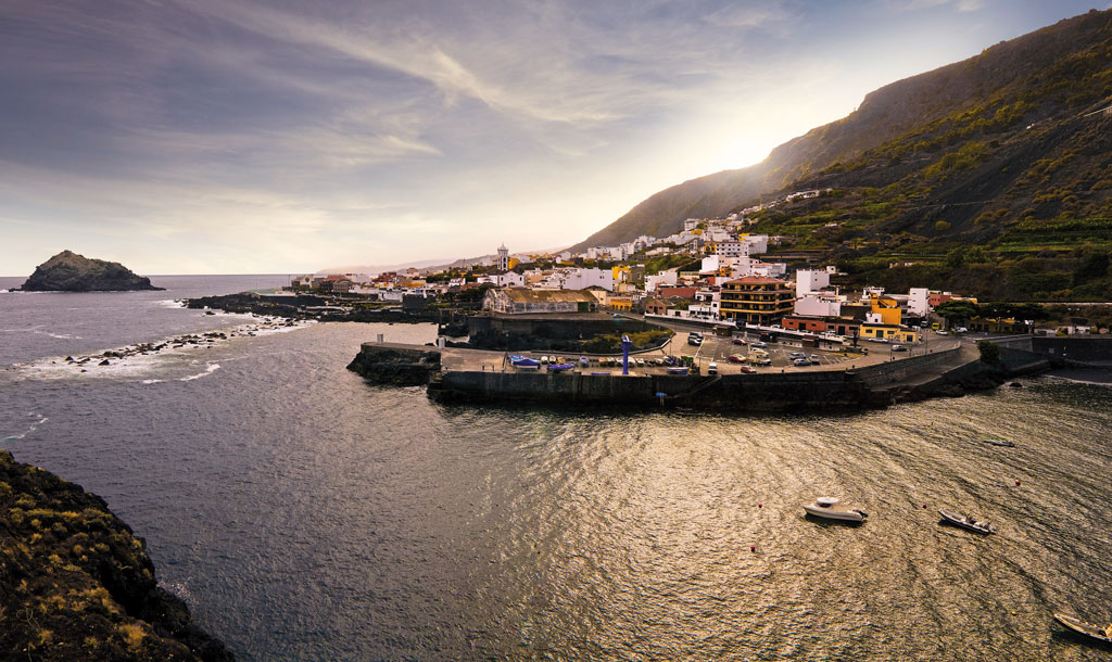 Village côtier près des montagnes à Tenerife au coucher du soleil.