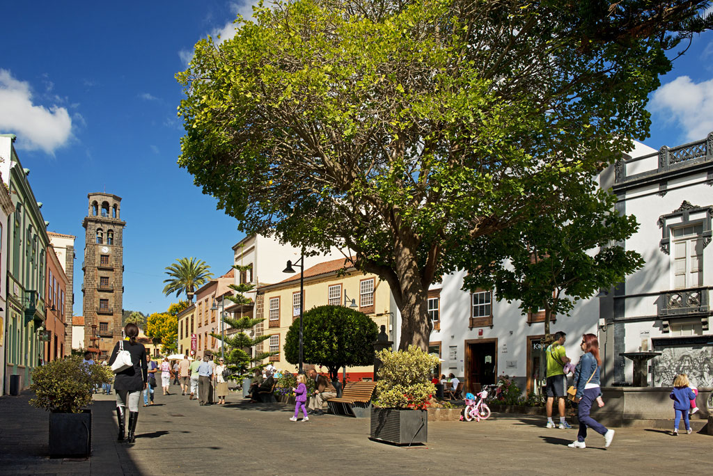 Des gens se promenant sur la place avec le clocher de l’église à La Laguna, Tenerife.