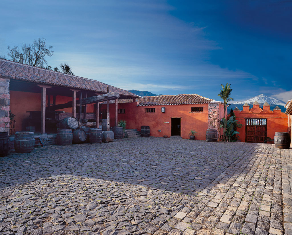 Terrasse d’un domaine traditionnel à Tenerife avec des tonneaux et une vue sur le mont Teide.