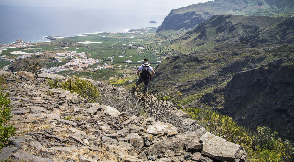Randonneur de montagne surplombant le paysage côtier de Tenerife.