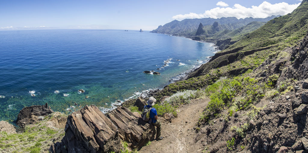 Sentier côtier avec vue sur la mer et la montagne à Tenerife. Personne qui marche.