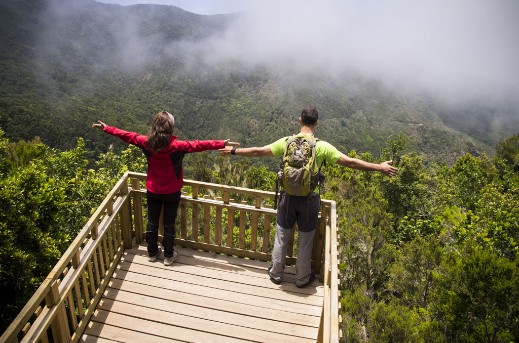 Deux personnes avec des sacs à dos à un point de vue dans la forêt à Tenerife.