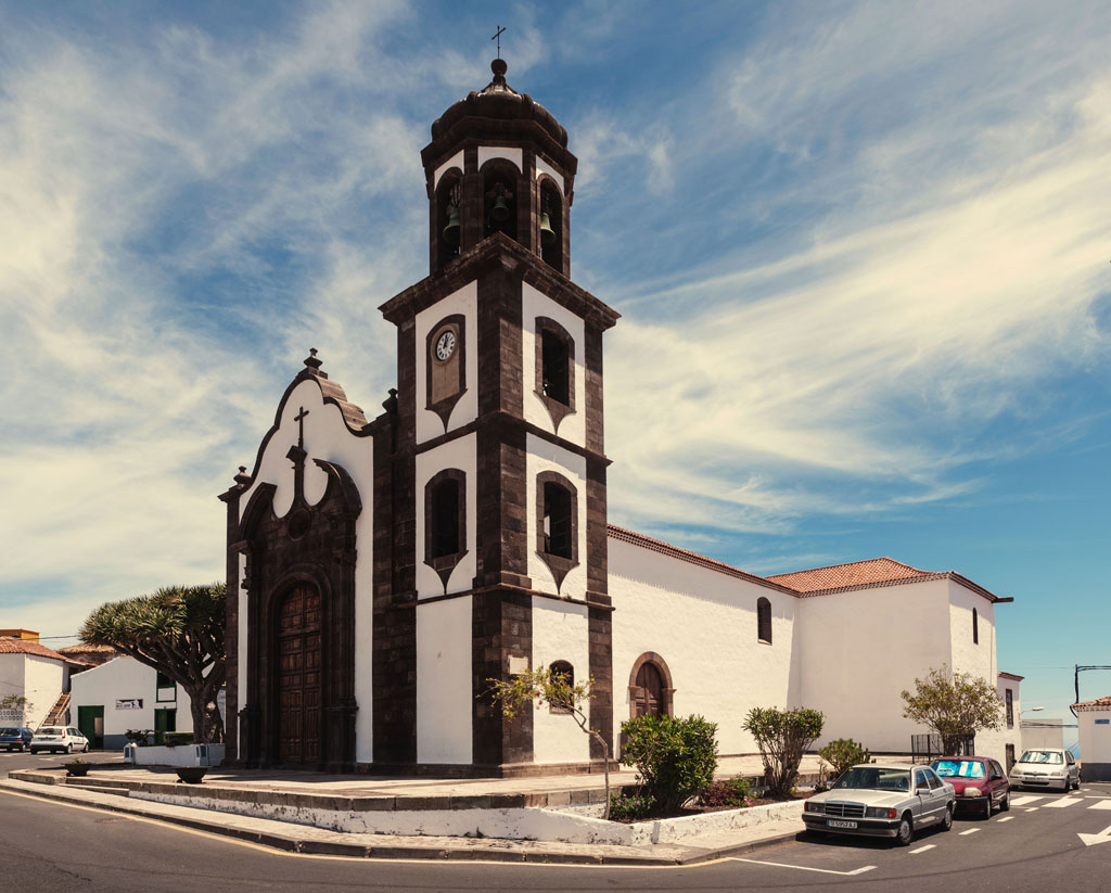 Église à Garachico, Tenerife, avec un ciel dégagé et des arbres tout autour.