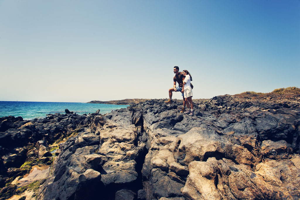 Un couple observe la mer depuis la côte rocheuse de Tenerife.