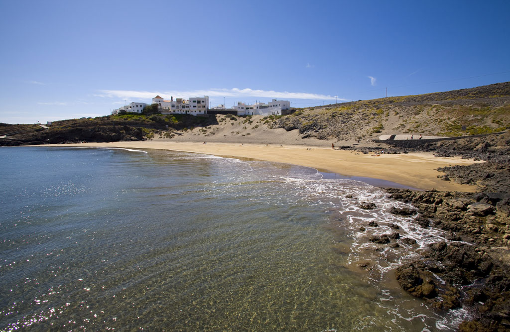 Plage avec du sable doré et des bâtiments en arrière-plan sur la côte de Tenerife.