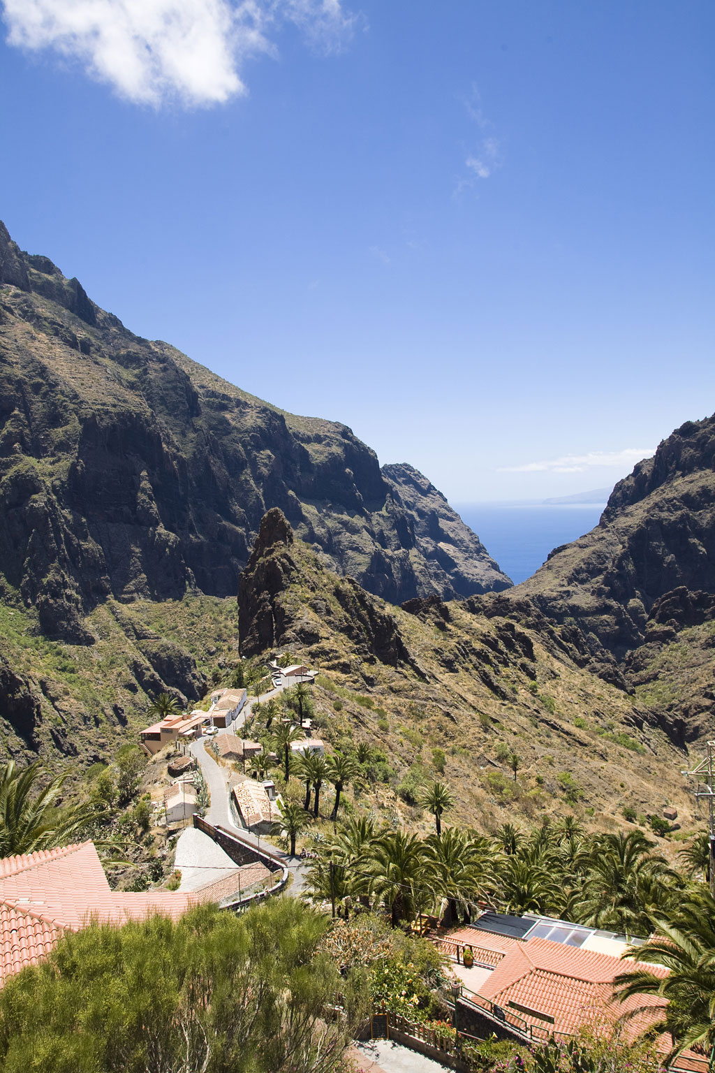 Vallée et maisons dans le ravin de Masca, à Tenerife, avec l’océan en arrière-plan.