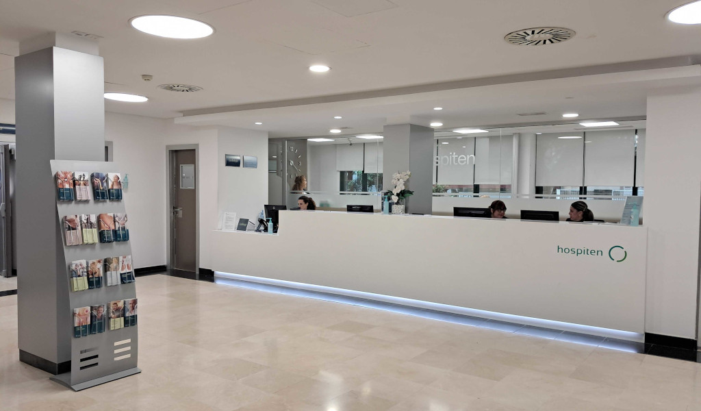 Accueil de l’hôpital Hospiten à Tenerife avec comptoir et brochures.