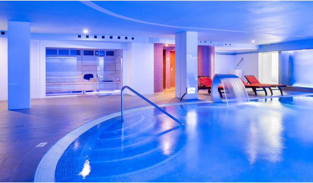 Piscine intérieure avec cascade et transats au spa de Tenerife.