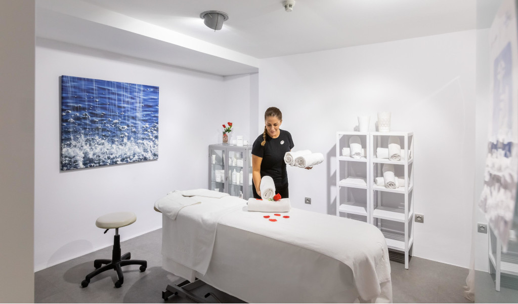 Salle de massage avec un thérapeute qui organise des serviettes blanches à Tenerife.