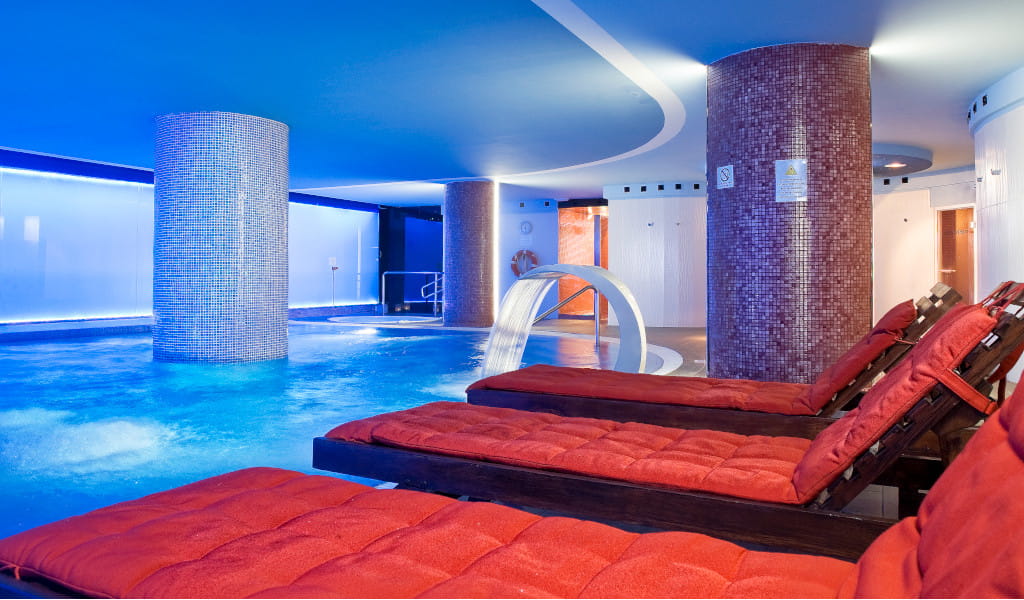 Zone spa avec piscine et chaises longues dans un hôtel à Tenerife.