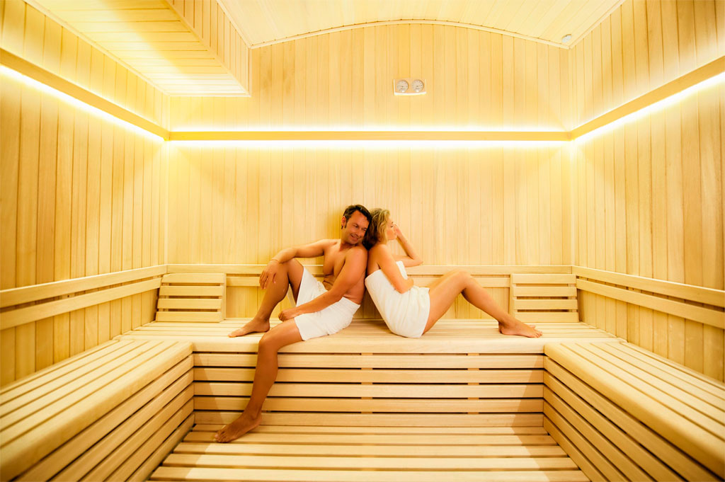 Un couple se détendant dans un sauna en bois d’un spa à Tenerife.
