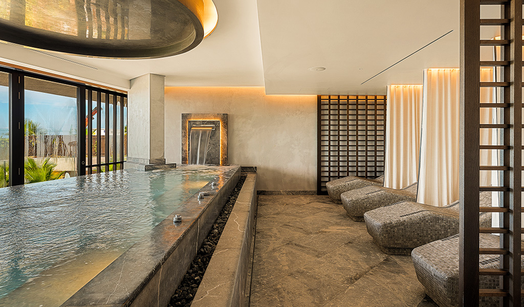 Spa intérieur avec piscine et chaises longues près de la fenêtre à Adeje, Tenerife.