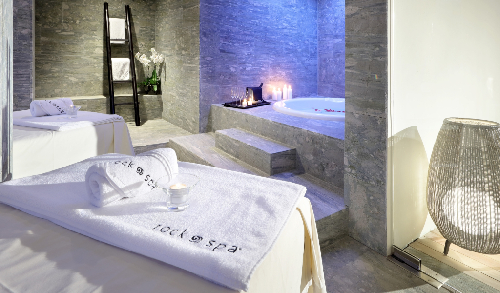 Spa avec table de massage, serviettes et jacuzzi éclairé à Tenerife.