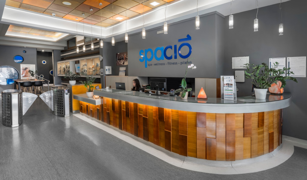 Accueil du spa Spacio à Tenerife avec une personne travaillant et une plante décorative.