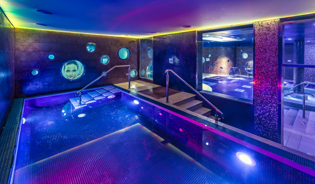 Piscine éclairée dans un spa à Tenerife avec des projections sur les murs.