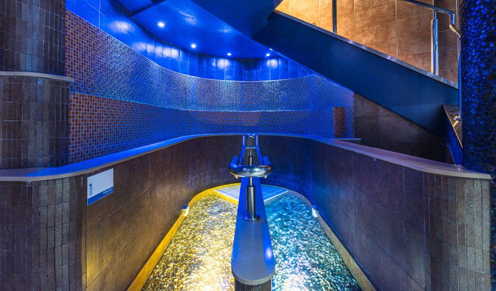 Chemin courbé avec de l’eau et mosaïques bleues illuminées, situé à Tenerife.