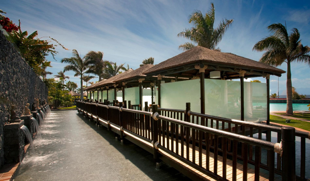 Passerelle en bois avec palmiers et murs à l’Hôtel Villa Cortés Tenerife.