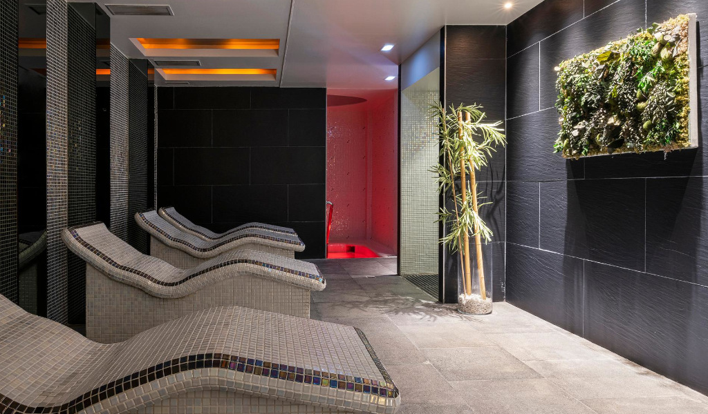 Salle de détente avec chaises longues et décorations végétales au spa de Tenerife.