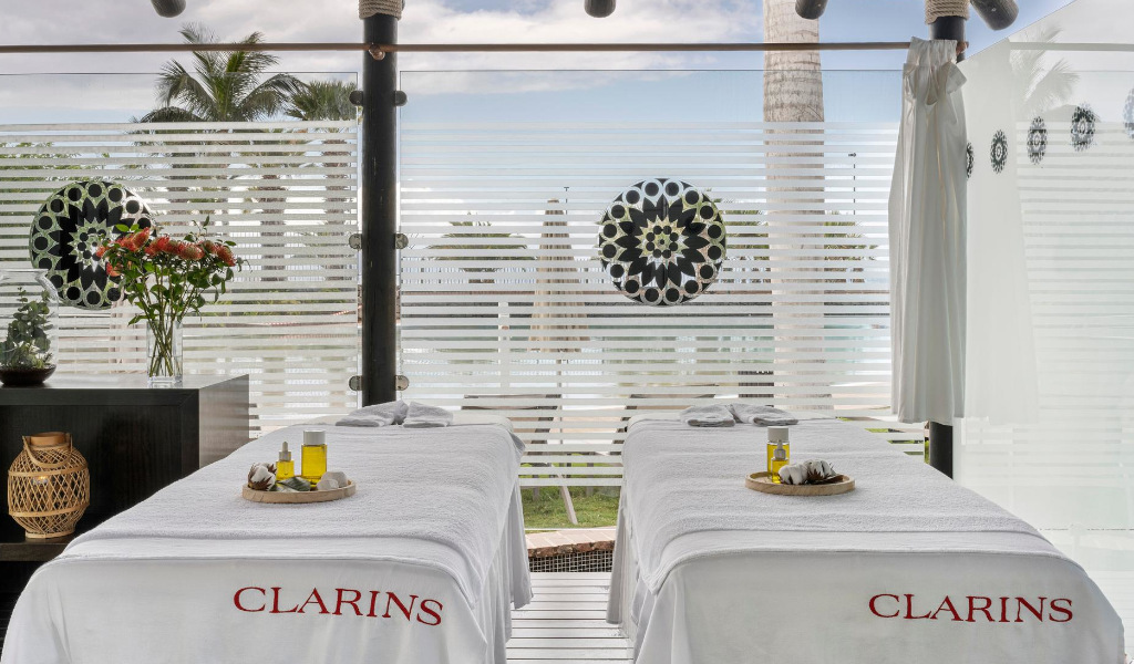 Table de massage à huiles dans le spa de Clarins, Tenerife, à côté d’une fenêtre décorée.