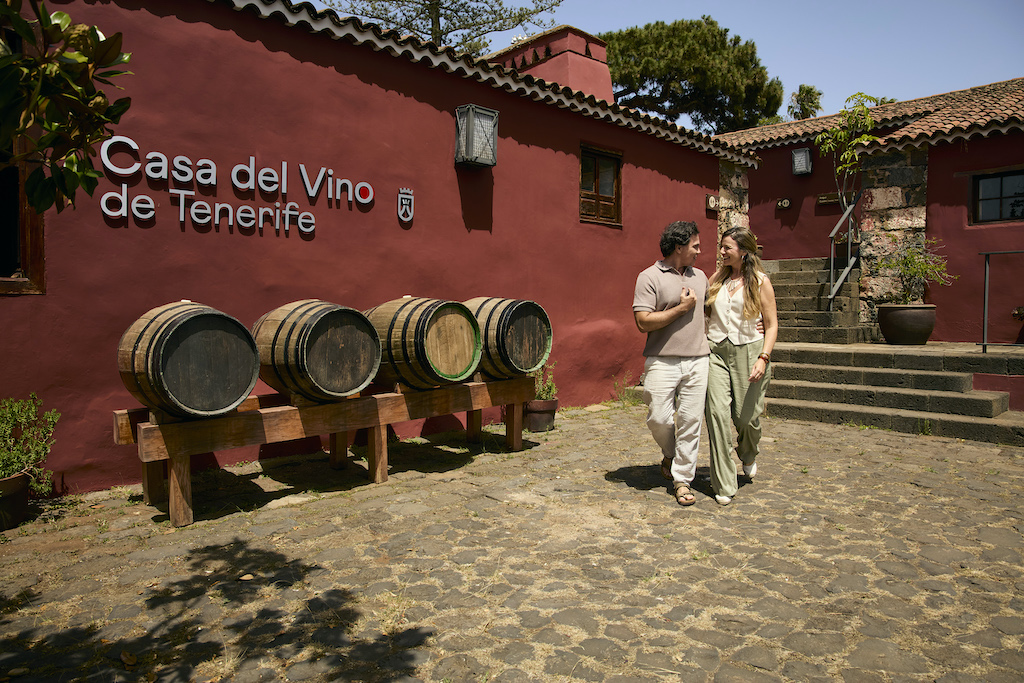 Un couple marchant à côté de tonneaux à la Casa del Vino de Tenerife.