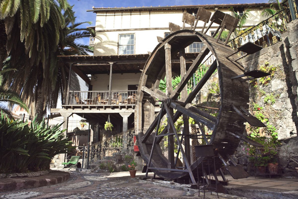 Vieux moulin à eau à La Orotava, entouré de végétation et d’architecture classique.