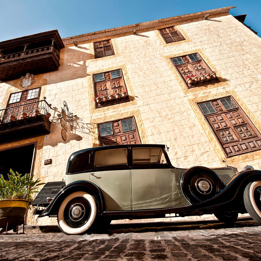 Voiture de collection garée devant un bâtiment historique à Tenerife.