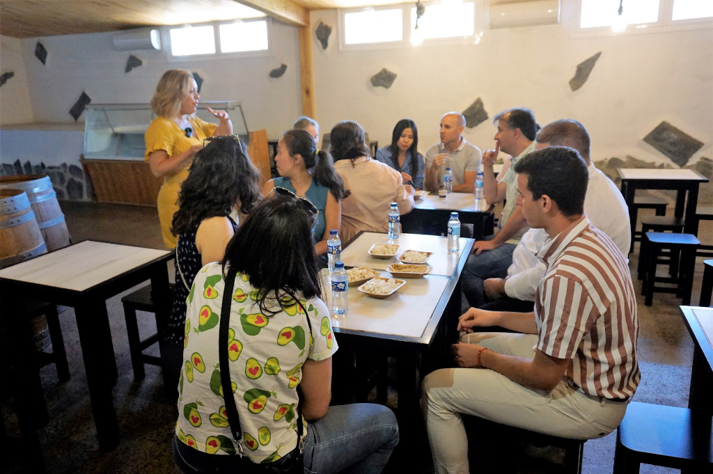 Un groupe de personnes se réunissait dans un domaine viticole à Tenerife, partageant la nourriture autour des tables.