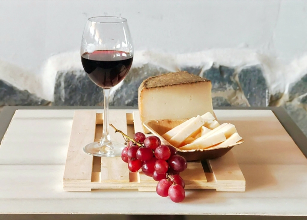 Un verre de vin rouge, du fromage et des raisins rouges sur une planche à Tenerife.