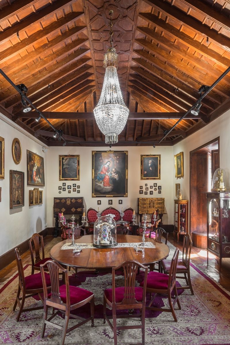 Salle à manger avec lustres, table ronde et plafond en bois, à Tenerife.