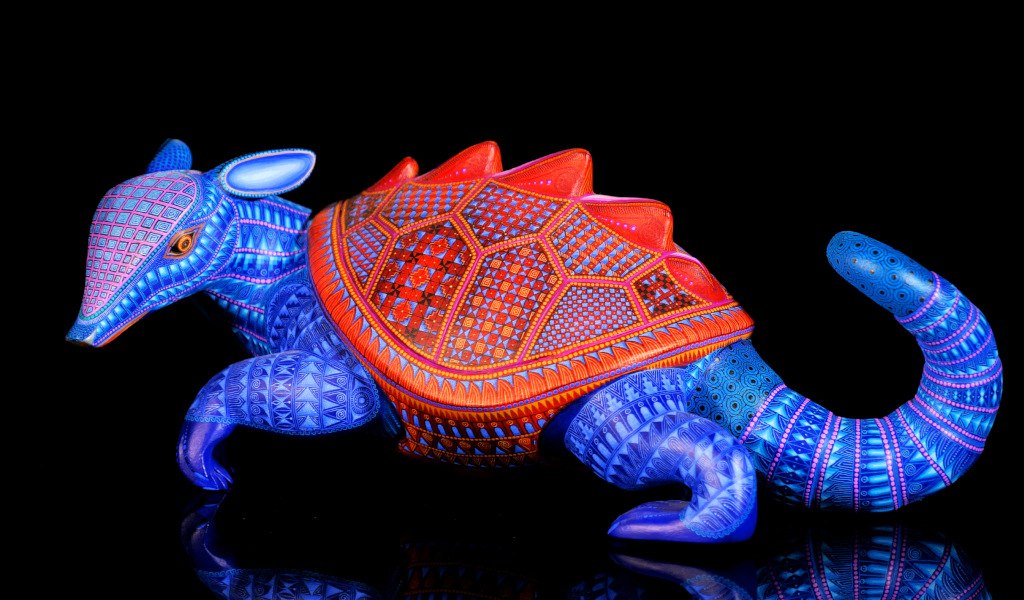 Tatou en bois sculpté aux couleurs vives et aux motifs géométriques.