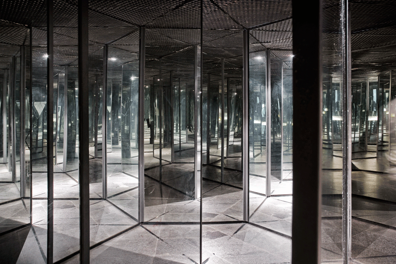 Couloir de miroirs créant de multiples reflets dans un labyrinthe.