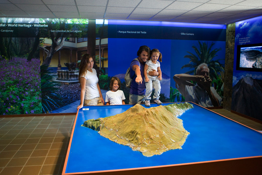 La famille observe une maquette du parc national du Teide lors d’une exposition intérieure.