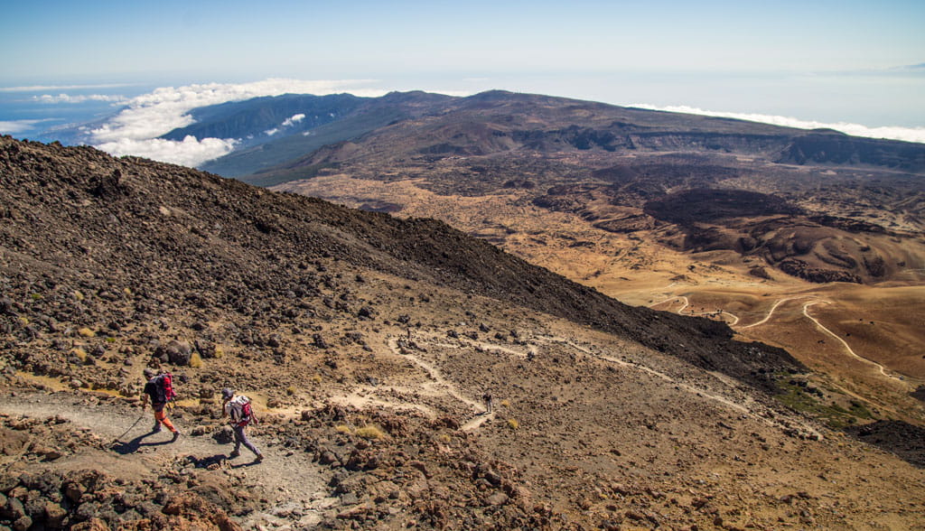Randonneurs sur le mont Teide, Tenerife, avec un paysage volcanique en arrière-plan.